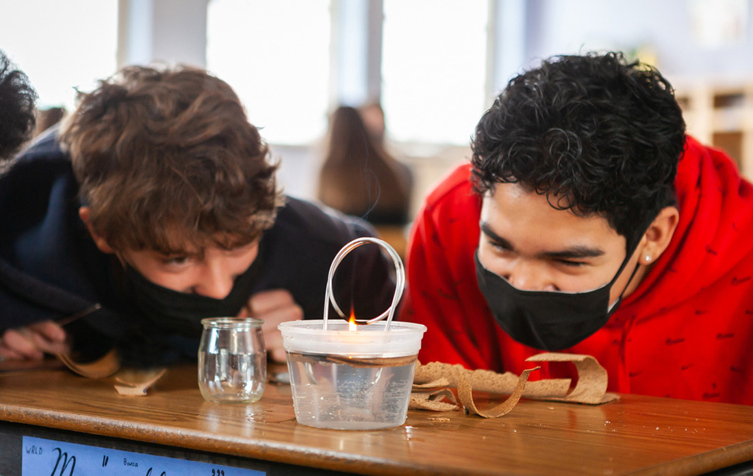 Two 8th grade students excitedly anticipate the result of their hand-built steam engine!